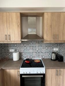 a kitchen with a stove and wooden cabinets at River Home in Agia Galini