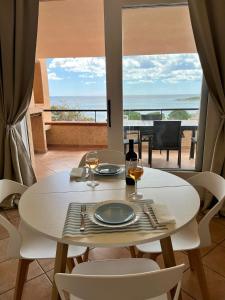 a table with two glasses of wine and a view of the ocean at Villa Elma in Villaputzu