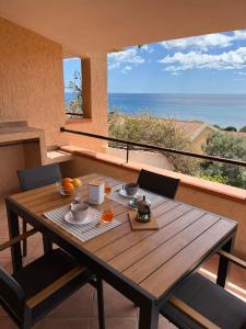 a wooden table and chairs with a view of the ocean at Villa Elma in Villaputzu
