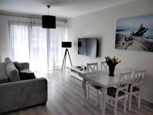 a living room with a table and a couch at Apartament Kasztanowy in Władysławowo
