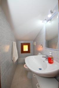 a bathroom with a sink and a mirror and a toilet at Casa sulla collina - Sant'Antioco in SantʼAntìoco