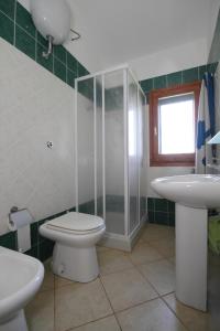 a bathroom with a toilet and a sink and a shower at Casa sulla collina - Sant'Antioco in SantʼAntìoco