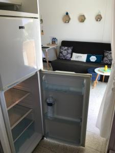 een koelkast met een deur open in de woonkamer bij Grand studio cosy à 300m de la mer avec parking in Canet-en-Roussillon