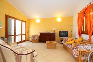 ein Wohnzimmer mit einem Sofa und einem TV in der Unterkunft Casa sulla collina - Sant'Antioco in SantʼAntìoco