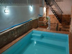 una grande piscina in una stanza con scala di La Casa del Abuelo Curro a Baños de la Encina