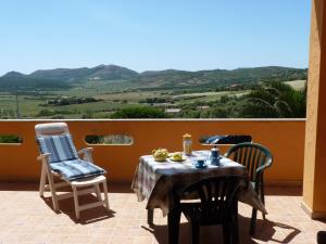 a table and two chairs on a patio with a view at Casa sulla collina - Sant'Antioco in SantʼAntìoco