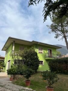ein grünes Haus mit Bäumen davor in der Unterkunft Secret Garden Egle in Caprino Veronese