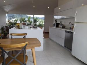 a kitchen with a wooden table and a white refrigerator at Habitación en penthouse en el centro histórico in Popayan