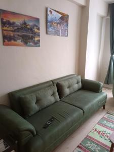 ein grünes Sofa im Wohnzimmer in der Unterkunft daily rental apartment 5 minutes to the airport in Pazar