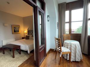 a bedroom with a bed and a table and a window at Quinta de Villanueva in Colombres