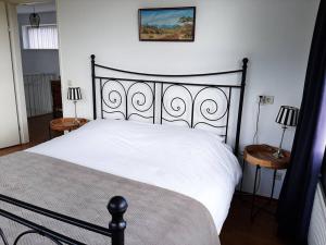 a bedroom with a white bed and two end tables at Gastehuisie Lekkerslaap in Zeewolde +36 photos