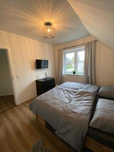 een slaapkamer met een bed en een raam bij Ferienwohnung Nahe der Nordsee in Hemmingstedt