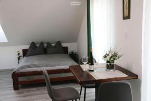 1 dormitorio con 1 cama y 1 mesa con copas de vino en Apartmány u Romany, en Mírkovice
