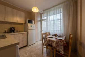 a kitchen with a table with chairs and a white refrigerator at Marvelous Riverside Flat in Ruse