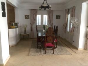 comedor con mesa y sillas en Blue family villa with large private pool en El-Shaikh Mabrouk