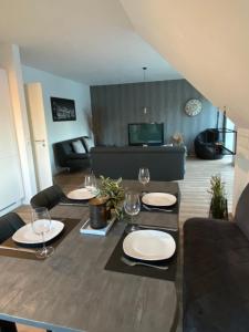 una sala de estar con una mesa con platos y copas de vino en Ferienwohnung Nahe der Nordsee, en Hemmingstedt