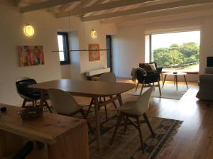 een woonkamer met een tafel en stoelen bij Casa do Norte in Prainha de Cima