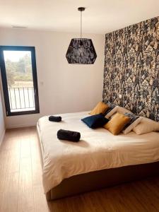 ein Schlafzimmer mit einem großen Bett mit Kissen darauf in der Unterkunft Villa moderne entre centre ville et nature in Nîmes