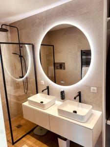 La salle de bains est pourvue de 2 lavabos et d'un grand miroir. dans l'établissement Villa moderne entre centre ville et nature, à Nîmes
