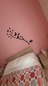 a bedroom with a bed with a group of birds on the wall at BeB I PORTICI in Cernobbio