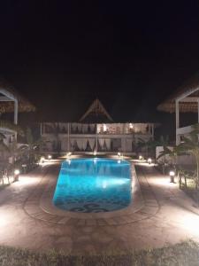 uma piscina à noite com luzes em DREAM HOUSE em Watamu