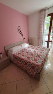 a bedroom with a bed in a room with pink walls at BeB I PORTICI in Cernobbio