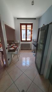 a kitchen with a tiled floor with a table and a window at BeB I PORTICI in Cernobbio