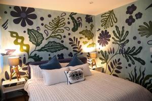 Un dormitorio con una cama con papel pintado floral. en Luxurious Mid Century Modern folk art home, en Ciudad de México