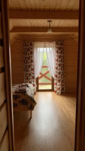 a bedroom with a bed and a window with curtains at Domki na wzgórzu 2 in Małe Ciche