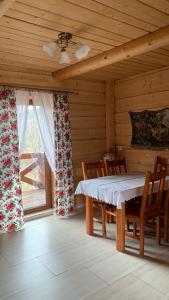 een eetkamer met een tafel en een raam bij Domki na wzgórzu 2 in Ciche Małe