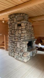 a stone fireplace in a cabin with a wooden ceiling at Domki na wzgórzu 2 in Małe Ciche