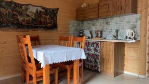 a kitchen with a table and chairs in a cabin at Domki na wzgórzu 2 in Małe Ciche