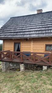 a log cabin with a wooden fence in front of it at Domki na wzgórzu 2 in Małe Ciche