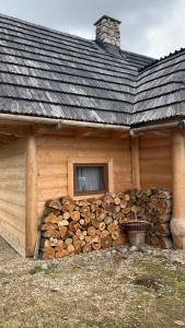 een blokhut met een raam en een stapel houtblokken bij Domki na wzgórzu 2 in Ciche Małe