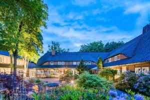 einen Blick nach außen auf ein Haus mit Garten in der Unterkunft Hotel Schäferhof in Schneverdingen