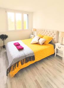 a bedroom with a large bed with yellow sheets and pillows at Bel appartement entre Disney Land et Paris in Chelles