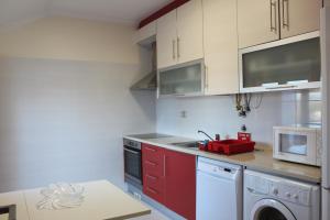 cocina con armarios rojos y lavavajillas rojo en Carlota House - Baleal, en Baleal 23 fotos más
