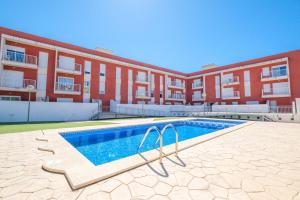 a swimming pool in front of a building at Apartamento GELUM Delta del Ebro in Sant Jaume d'Enveja