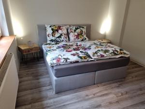 1 cama con edredón de flores en un dormitorio en 5 Sterne Bahnhoftraum, Appartement "Waldliebe", en Braunfels