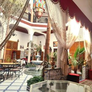 a lobby with tables and chairs in a building at Riad Chennaoui in Marrakesh