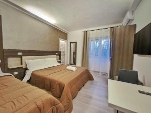 a hotel room with two beds and a desk at Kunesias B&B in Cinisi