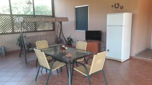 a dining room with a table and chairs and a refrigerator at Tenuta Santa Giovanna in Poggiardo