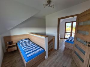 sypialnia z 2 łóżkami i przesuwnymi szklanymi drzwiami w obiekcie Domki luksusowe Kapitan w mieście Ustronie Morskie