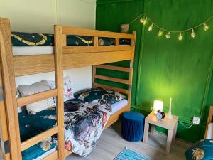 a bedroom with two bunk beds and a green wall at Chatky Pod Javory in Nejdek