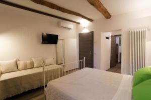 um quarto com duas camas e uma televisão na parede em La casa di Ines em San Gimignano