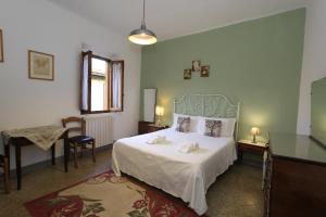 um quarto com uma cama, uma mesa e uma secretária em La casa di Ines em San Gimignano