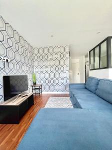 ein Wohnzimmer mit einem blauen Sofa und einem TV in der Unterkunft Bel appartement complet: in Villetaneuse