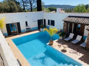 a swimming pool in front of a house at Le Patio Bleu in La Crau