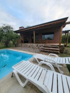 a couple of white chairs next to a swimming pool at La Peperina in San Javier