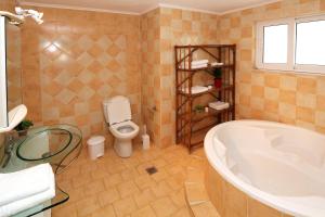 a bathroom with a tub and a toilet at Villa Saradari in Hersonissos